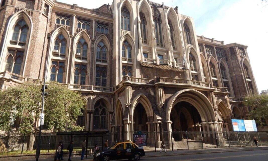Ilustración de una balanza de la justicia junto a libros y un edificio universitario.